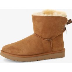 UGG - Kozaki damskie ze skóry – Mini Bailey Bow II, brązowy. Pomarańczowe kozaki damskie Ugg, z satyny, bez obcasa, bez zapięcia. Za 899,95 zł.