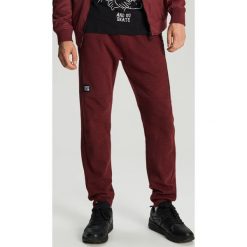 Dresowe joggery - Bordowy. Czerwone spodnie męskie Cropp, s, bez wzorów, z dresówki. Za 99,99 zł.