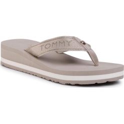 Japonki TOMMY HILFIGER - Metallic Mid Wedge Beach Sandal FW0FW04791 Stone AEP. Brązowe klapki damskie TOMMY HILFIGER, bez wzorów, z tworzywa sztucznego, bez obcasa, na obcasie. W wyprzedaży za 149,00 zł.
