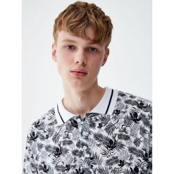 Koszulka polo z tropikalnym nadrukiem liści. Białe koszulki męskie marki Pull&Bear, m, z nadrukiem, z krótkim rękawem. Za 59,90 zł.