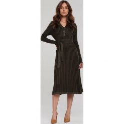 Ciemnozielona Sukienka Brendale. Zielone sukienki damskie Renee, na zimę, s, bez wzorów, z dzianiny, eleganckie, bez kołnierzyka, bez rękawów, długie, midi, rozkloszowane. Za 149,99 zł.
