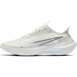 Buty "Zoom Gravity" w kolorze beżowym do biegania. Brązowe buty sportowe damskie do biegania. W wyprzedaży za 279,95 zł.