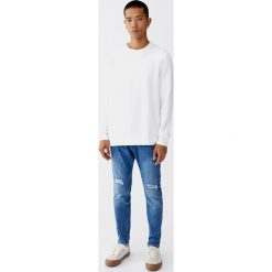 Średnioniebieskie jeansy carrot fit. Niebieskie jeansy męskie marki Pull&Bear, m, bez wzorów. Za 139,00 zł.