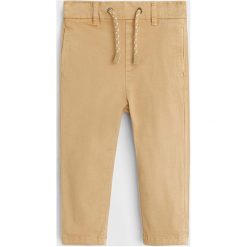 Mango Kids - Spodnie dziecięce 80 - 104 cm. Żółte spodnie chłopięce Mango Kids, bez wzorów, z elastanu, casualowe. Za 69,90 zł.