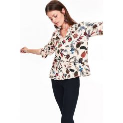 Bluzka damska w kwiatowy wzór, z falbaną. Białe bluzki damskie Top Secret, w kwiaty, z tkaniny, eleganckie, z dekoltem w serek, bez rękawów. W wyprzedaży za 59,99 zł.