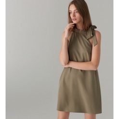 Sukienka z wiązaniem przy dekolcie - Khaki. Brązowe sukienki damskie marki Mohito, na imprezę, bez wzorów, bez kołnierzyka, bez rękawów. Za 79,99 zł.
