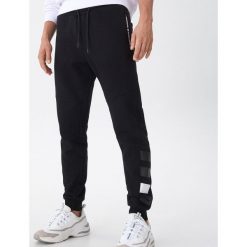 Joggery z nadrukiem - Czarny. Czarne spodnie męskie House, s, z nadrukiem. Za 119,99 zł.