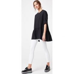 Bluzka z falbanką na dole czarna - l/xl. Czarne bluzki damskie e-margeritka.pl, s, bez wzorów, z bawełny, eleganckie, z falbankami, z długim rękawem. Za 148,99 zł.