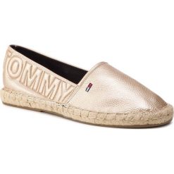 Espadryle TOMMY JEANS - Shiny Metallic Espadrille EN0EN00453 Light Gold 715. Żółte półbuty damskie Tommy Jeans, na co dzień, bez wzorów, z jeansu, bez obcasa, na płaskiej podeszwie, bez zapięcia. Za 299,00 zł.