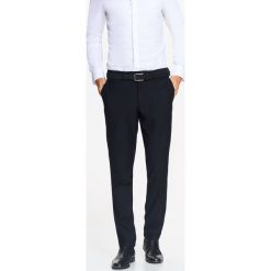 Spodnie męskie eleganckie o zwężanym kroju z gładkiej tkaniny. Czarne spodnie garniturowe męskie z tkaniny, eleganckie. W wyprzedaży za 59,99 zł.