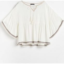 Bluzka w stylu boho - Kremowy. Białe bluzki damskie Reserved, bez wzorów, boho, bez kołnierzyka, bez rękawów. W wyprzedaży za 49,99 zł.