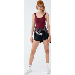 Body na ramiączkach z lampasami. Czerwone koszulki damskie marki Pull&Bear, bez wzorów, bez kołnierzyka, z krótkim rękawem. Za 49,90 zł.