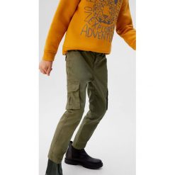 Mango Kids - Spodnie dziecięce Kike 110-164 cm. Żółte spodnie chłopięce Mango Kids, bez wzorów, z elastanu. W wyprzedaży za 69,90 zł.