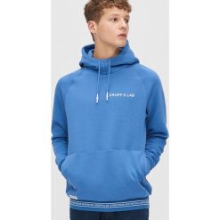 Bluza z nadrukiem na plecach - Niebieski. Niebieskie bluzy męskie Cropp, s, z nadrukiem, z dekoltem na plecach, bez rękawów, bez kaptura. Za 129,99 zł.