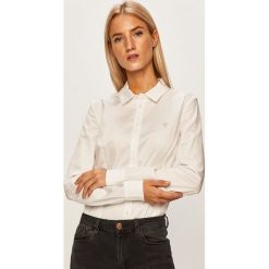 Guess Jeans - Koszula. Białe bluzki damskie Guess Jeans, na co dzień, s, z aplikacjami, z elastanu, klasyczne, z klasycznym kołnierzykiem, z długim rękawem. W wyprzedaży za 199,90 zł.