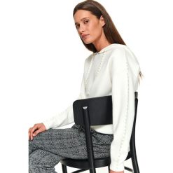 Sweter zdobiony perełkami. Białe swetry damskie Top Secret, na zimę, z aplikacjami, z dzianiny, eleganckie, bez rękawów, z kapturem. W wyprzedaży za 149,99 zł.