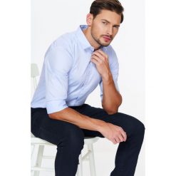 Koszula męska elegancka z jedwabistym wykończeniem tkaniny o dopasowanym kroju. Niebieskie koszule męskie Top Secret, m, bez wzorów, z tkaniny, eleganckie, z klasycznym kołnierzykiem, z długim rękawem. W wyprzedaży za 39,99 zł.