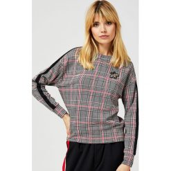 Bluza w kratę z lampasami i aplikacją. Czerwone bluzy damskie Moodo, l, z aplikacjami, z elastanu, z długim rękawem, długie, bez kaptura. Za 39,99 zł.