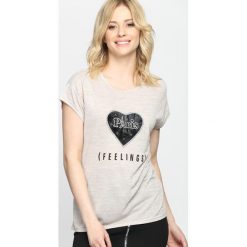 Beżowy T-shirt From Eden. Brązowe bluzki z odkrytymi ramionami Born2be, l, z nadrukiem, z okrągłym kołnierzem, z krótkim rękawem. Za 29,99 zł.