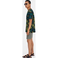Koszulka z bawełny z tropikalnymi liśćmi. Czarne koszulki męskie Pull&Bear, m, bez wzorów, z bawełny, bez kołnierzyka, z krótkim rękawem, krótkie. Za 29,90 zł.