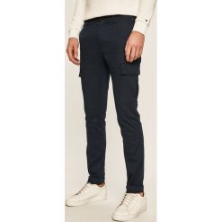 Tommy Hilfiger - Spodnie. Niebieskie spodnie męskie TOMMY HILFIGER, na co dzień, bez wzorów, z elastanu, casualowe. Za 579,90 zł.