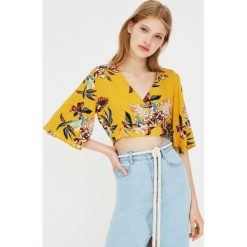 Top z dekoltem w serek w kwiaty. Szare topy damskie Pull&Bear, w kwiaty, z dekoltem w serek, z krótkim rękawem. Za 79,90 zł.