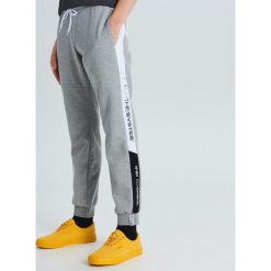 Joggery w sportowym stylu z lampasem - Jasny szary. Szare spodnie męskie Cropp, s, bez wzorów, sportowe. Za 99,99 zł.