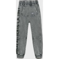 Guess Jeans - Spodnie dziecięce 118-175 cm. Szare spodnie chłopięce Guess Jeans, z nadrukiem, z elastanu. W wyprzedaży za 139,90 zł.
