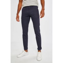 Lacoste - Spodnie. Pomarańczowe spodnie męskie Lacoste, l, bez wzorów, z elastanu. W wyprzedaży za 239,90 zł.