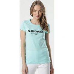 Jasnoniebieski T-shirt Brisa. Niebieskie bluzki damskie Born2be, s, z napisami, z jeansu, z okrągłym kołnierzem, z krótkim rękawem. Za 39,99 zł.