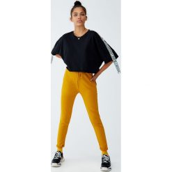 Spodnie z dzianiny dresowej basic. Czerwone spodnie damskie marki Pull&Bear, z dzianiny. Za 59,90 zł.