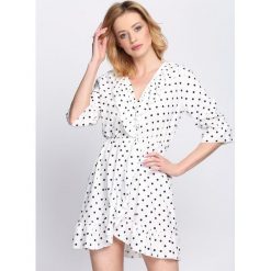 Biała Sukienka Flavorer. Białe sukienki damskie Born2be, na imprezę, na lato, s, z aplikacjami, retro, bez kołnierzyka, bez rękawów, kopertowe. Za 79,99 zł.