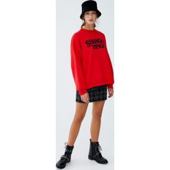 Bluza Netflix Stranger Things z logo z przodu. Czerwone bluzy damskie marki Pull&Bear. Za 109,00 zł.