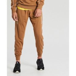 Dresowe joggery - Beżowy. Brązowe spodnie męskie Cropp, s, bez wzorów, z dresówki. Za 99,99 zł.