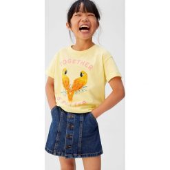 Mango Kids - Top dziecięcy Loros 110-152 cm. Żółte bluzki dziewczęce Mango Kids, z nadrukiem, z bawełny, z okrągłym kołnierzem, z krótkim rękawem, krótkie, bez kaptura. W wyprzedaży za 29,90 zł.