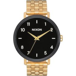 Zegarek kwarcowy "Arrow" w kolorze czarno-złotym. Żółte, analogowe zegarki damskie Nixon, złote. W wyprzedaży za 259,95 zł.