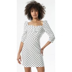 Biała Sukienka Meliliphis. Białe sukienki damskie Born2be, s, w grochy, retro, bez kołnierzyka, z długim rękawem, długie, mini, dopasowane. Za 99,99 zł.