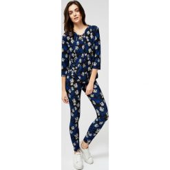 Legginsy z motywem kwiatów. Czarne spodnie damskie Moodo, s, z nadrukiem, z elastanu. Za 14,99 zł.