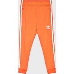 Adidas Originals - Spodnie dziecięce 128-164 cm. Pomarańczowe spodnie chłopięce adidas Originals, bez wzorów, z poliesteru, casualowe. Za 169,90 zł.