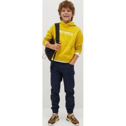 Mango Kids - Jeansy dziecięce Comfy 110-164 cm. Niebieskie spodnie chłopięce Mango Kids, bez wzorów, z elastanu. Za 89,99 zł.
