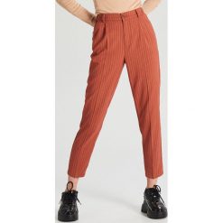 Spodnie chino - Brązowy. Pomarańczowe spodnie damskie Cropp, bez wzorów. Za 89,99 zł.