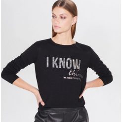 Sweter z holograficznym nadrukiem - Czarny. Czarne swetry damskie Mohito, xs, z nadrukiem. W wyprzedaży za 29,99 zł.