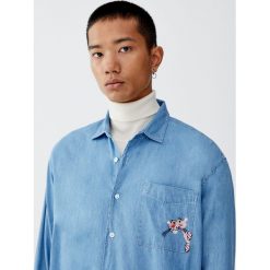 Koszula jeansowa z Różową Panterą. Różowe koszule męskie jeansowe Pull&Bear, m, bez wzorów, bez kołnierzyka, z długim rękawem, długie. Za 99,90 zł.