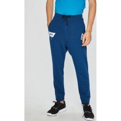 Reebok - Spodnie. Niebieskie spodnie męskie Reebok, s, z nadrukiem, z bawełny, sportowe. W wyprzedaży za 129,90 zł.