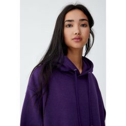 Luźna bluza z kapturem. Fioletowe bluzy damskie marki Pull&Bear, bez wzorów, bez rękawów, z kapturem. Za 89,90 zł.