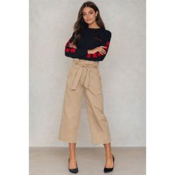 NA-KD Trend Szerokie spodnie bawełniane z wiązaniem w talii - Beige. Brązowe spodnie damskie z wysokim stanem marki NA-KD Trend, w paski, z bawełny, z podwyższonym stanem. W wyprzedaży za 60,97 zł.