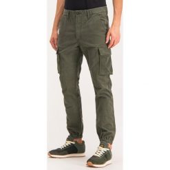 Joggery Superdry Recruit Flight Grip M7000018A. Zielone jeansy męskie Superdry, m, bez wzorów, z elastanu. W wyprzedaży za 259,00 zł.