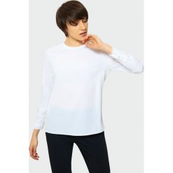 Elegancka biała bluzka. Białe bluzki damskie Greenpoint, bez wzorów, z poliesteru, eleganckie, bez kołnierzyka, bez rękawów. Za 39,99 zł.