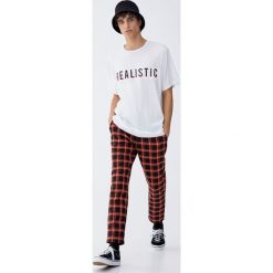 Koszulka z wypukłym napisem w szkocką kratkę. Białe koszulki męskie Pull&Bear, m, z napisami, bez kołnierzyka, z krótkim rękawem, krótkie. Za 59,90 zł.