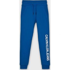 Calvin Klein Jeans - Spodnie dziecięce 128-176 cm. Niebieskie spodnie chłopięce Calvin Klein Jeans, z nadrukiem, z bawełny, casualowe. Za 269,90 zł.